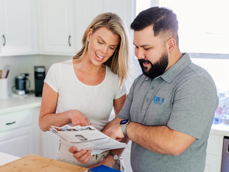 Dixon Painting team member showing client brochures in home