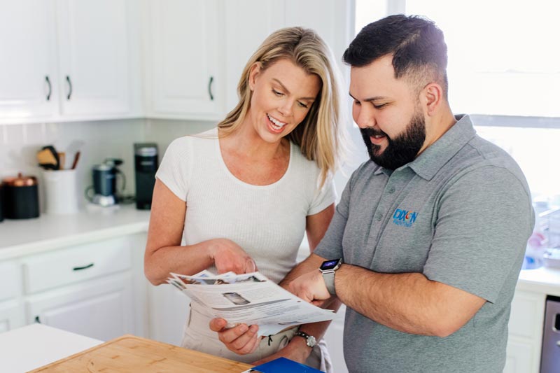 Dixon Painting team member showing client brochures in home