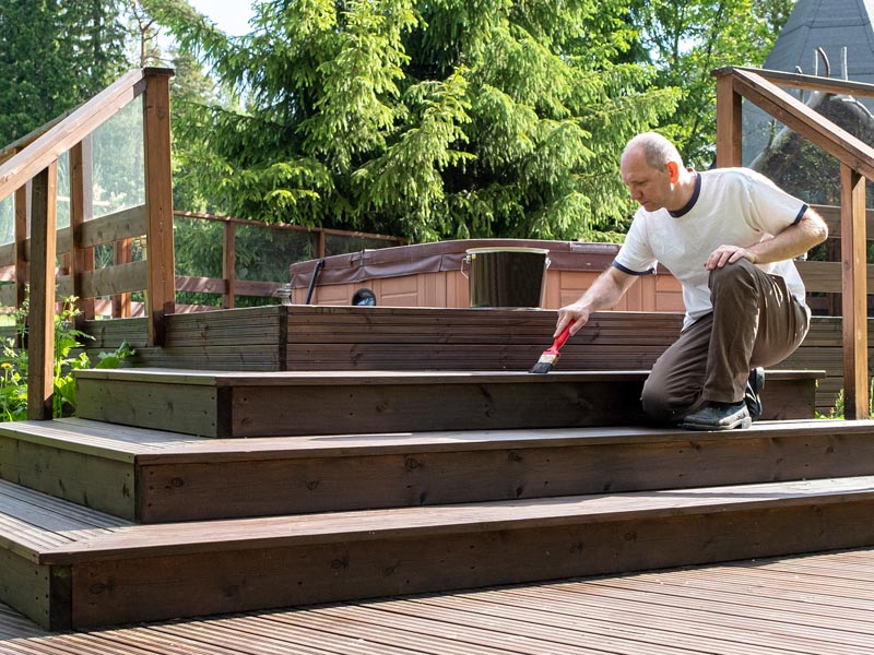 man painting the deck