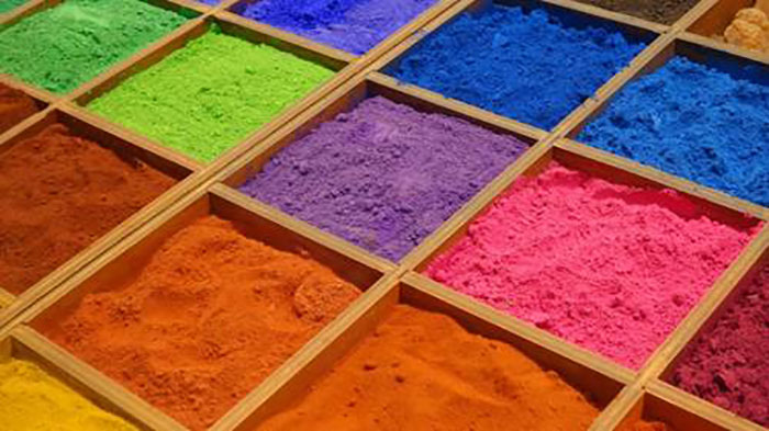 a group of colorful powders in wooden boxes